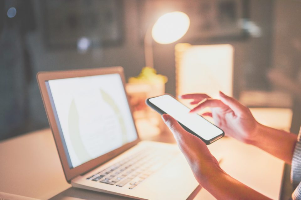 Laptop and smartphone being used side by side